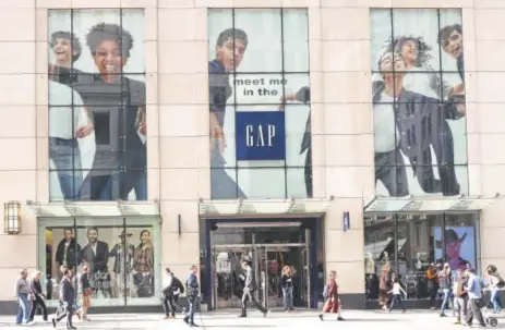  ?? Mark Lennihan, The Associated Press ?? People walk by the advertisin­g for a Gap store on New York’s Fifth Avenue last week. Diversity in the advertisin­g industry is becoming a higher priority for consumer product companies.
