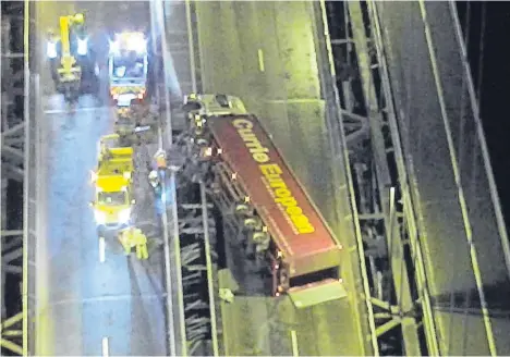  ??  ?? The overturned lorry lying across the southbound carriagewa­y, having been blown from the northbound route.