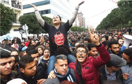  ??  ?? Tunisians shout slogans during a demonstrat­ion against the government and price hikes on Tuesday. (AFP)