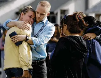  ??  ?? D.J. Hamburger, a Saugus High School teacher, comforts a student Thursday after reports of a shooting at the school in Santa Clarita, Calif., about 30 miles northwest of L.A.