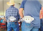  ?? JIM THOMPSON/JOURNAL ?? Wade Mulcock, left, and Eugene Mora have their sheep head bidding paddles at the ready while waiting for just the right animal on which to bid.