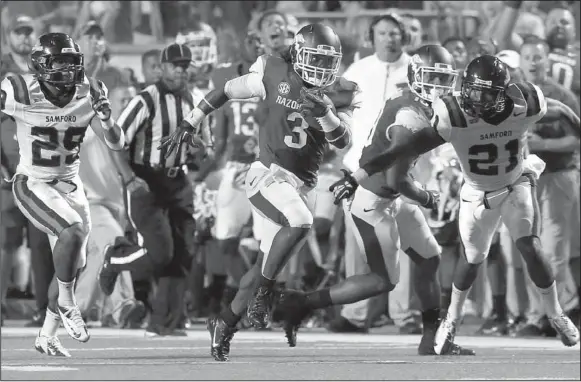  ?? Arkansas Democrat-Gazette/RICK McFARLAND ?? Arkansas freshman running back Alex Collins (3) gets past Samford defenders Tonne Osaigbovo (29) and James Bradberry (21) for a big gain during Saturday’s game at War Memorial Stadium in Little Rock. Collins finished with 172 yards and 1 touchdown on...