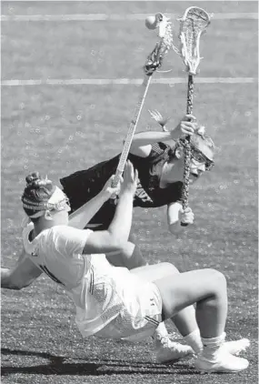  ?? KARL MERTON FERRON/BALTIMORE SUN ?? Navy’s Natalie Irwin fouls Loyola’s Livy Rosenzweig, who had two goals and six assists.