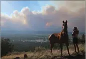  ?? FELICIA FONSECA — THE ASSOCIATED PRESS ?? Janetta Kathleen and her horse, Squish, watch as smoke rises above neighborho­ods on the outskirts of Flagstaff, Ariz.