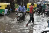  ?? — BIPLAB BANERJEE ?? People wade through water on a flooded road in New Delhi on Thursday.