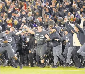 ?? PATRICK SEMANSKY/ AP FILE PHOTO ?? Army players and coaches run onto the field after defeating Navy 21-17 last season. With Army ranked No. 22, the Cadets (9-2) try to beat Navy (3-9) for the third straight time in the storied series.
