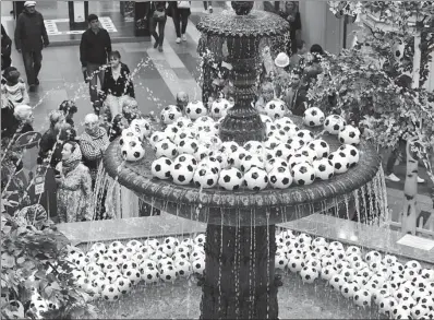  ?? ANDREY RUDAKOV / BLOOMBERG ?? Shoppers in Moscow enjoy the sight of soccer balls floating in a water fountain display at a mall on June 10. The event, which began on June 14, is expected to cause a 10-15 percent rise in sales of new TVs, sportswear, food and beverages in host...