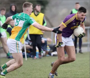  ??  ?? Glen Malone of Wexford under pressure from Offaly midfielder Peter Cunningham.