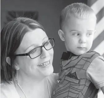  ?? PAUL DALY, THE CANADIAN PRESS ?? Kelly Knee of Torbay, N.L., holds her youngest son, 20-month-old Jacob, who was born after Knee underwent treatment for cancer.