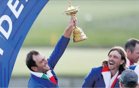  ?? ALASTAIR GRANT/THE ASSOCIATED PRESS ?? Europe’s Francesco Molinari holds up the Ryder Cup following his team’s decisive win in France Sunday.