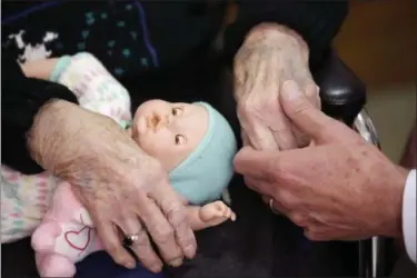  ?? CARLOS OSORIO — THE ASSOCIATED PRESS FILE ?? A son, at right, holds his mother’s hand as they talk at her nursing home in Adrian, Mich. U.S. adults providing long-term care for elderly relatives have a shortage of medical training but plenty of commitment, according to a new poll.