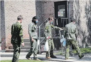  ?? RICHARD LAUTENS TORONTO STAR FILE PHOTO ?? Military personnel are seen changing shifts behind the Eatonville Care Centre on May 26. The long-term-care centre is among the facilities in Toronto with 40 or more COVID-19 deaths.