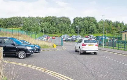  ?? Picture: Paul Reid. ?? Parked vehicles stack up near the school.