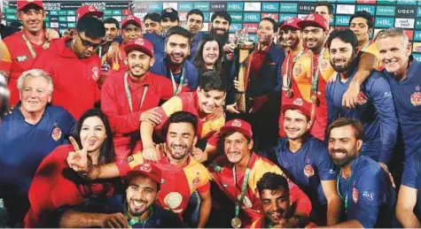  ?? AP ?? ■ Officials and players of Islamabad United team celebrate with the Pakistan Super League trophy at National stadium in Karachi on Sunday. New Zealander Luke Ronchi entertaine­d cricket-starved fans in Karachi with a blistering half-century.