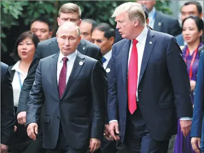 ?? JORGE SILVA / REUTERS ?? US President Donald Trump and Russia's President Vladimir Putin talk during the family photo session at the APEC leaders’ meeting in Da Nang, Vietnam, on Saturday.