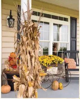  ??  ?? Bottom: Mums, pumpkins, cornstalks and a rustic wooden cart bring harvest flair to the Hirsch family’s spacious front porch.