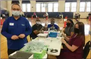  ?? EVAN BRANDT — MEDIANEWS GROUP ?? Ed Hudon, standing, is the owner of The Medicine Shoppe in Boyertown. He was assisted preparing vaccinatio­ns Friday by a team of profession­al nurses. From right, they are Maryrose Donnelly, Melinda Hoagey, Vivien Adeoye and Troy Nixon.