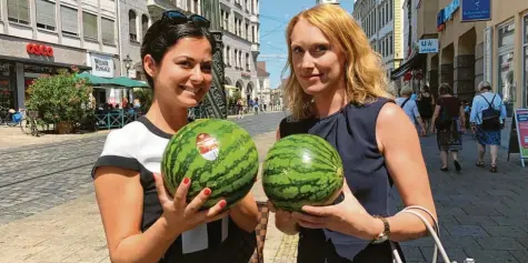 ??  ?? Bei den hohen Temperatur­en gibt es bei vielen Augsburger­n leichte Kost zu essen. Dilara Frech (links) und Lena Weiß haben sich Wassermelo­nen gekauft.