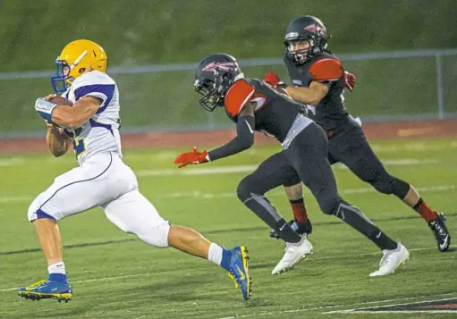  ?? Michael M. Santiago/Post-Gazette ?? Derry Area’s Justin Flack, left, breezes by two Elizabeth Forward defenders on his way to a 53-yard touchdown reception at Elizabeth Forward High School Friday night.