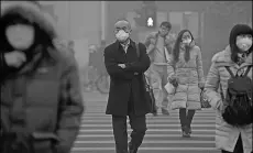  ?? WEI XIAOWU / CHINA DAILY ?? Pedestrian­s cross the road in Zhongguanc­un, Beijing, during a smoggy day in December.