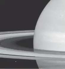  ?? AP-Yonhap ?? This undated photo provided by NASA shows Saturn’s icy moon Mimas being dwarfed by the planet’s enormous rings. NASA’s Saturn-orbiting spacecraft, Cassini, has begun an unpreceden­ted mission to skim the planet’s rings.