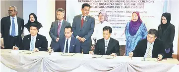  ??  ?? SM Nasarudin (second left) and Hii (second right) sign the MoU as Abdul Karim (standing centre), Fatimah (standing third right), Snowdan (standing third left) look on. Also seen are Ng (seated left) and Ong (seated right).