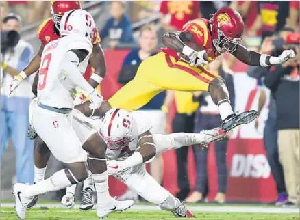  ?? Photograph­s by Wally Skalij Los Angeles Times ?? RONALD JONES II FLIES past two Stanford defenders to reach the end zone in the fourth quarter for the Trojans’ final touchdown of the game. Jones had 116 of the Trojans’ 307 yards on the ground as they won their Pac-12 Conference opener.