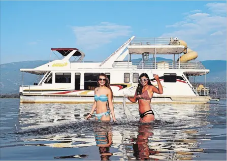  ?? PHOTOS BY STEVE MACNAULL ?? Lauren Hunt, left, and Grace MacNaull in front of Amity II, their five-bedroom, two-bathroom floating luxury digs for the weekend.