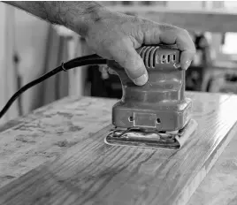  ?? PHOTO CREDIT: ROBERT MAXWELL ?? This 1/4-sheet finishing sander is being used with 240-grit sandpaper to smooth urethane before applying another coat.