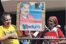  ?? ARIANA CUBILLOS THE ASSOCIATED PRESS ?? Supporters of Venezuela's president, Nicolas Maduro, hold a poster of him as he is sworn-in for a second term in Caracas on Thursday.