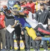  ??  ?? UCLA receiver Jaylen Erwin, left, is interfered with by Aztecs cornerback Luq Barcoo in fourth quarter.