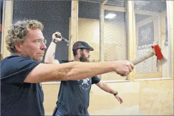  ?? COLIN CHISHOLM ?? Fred Ansems, left, and Steve Rex both give their favourite axes a throw at HaliMax Axe Throwing in Kentville.