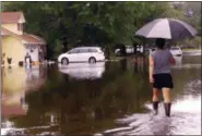  ?? JAY REEVES — THE ASSOCIATED PRESS ?? In this image taken from video, Erin West walks down a flooded street in her neighborho­od after Tropical Storm Cindy, Thursday in Ocean Springs, Miss. Persistent drainage problems frustrate residents, some of whom couldn’t drive to work because of the...