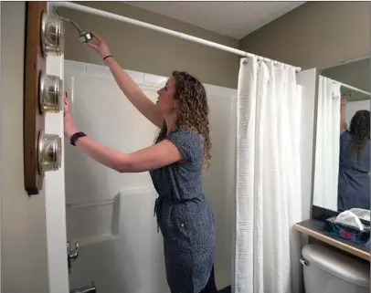  ?? Photo submitted to The McLeod River Post ?? Homeowner Rihanna McPhee checks the pressure of her new shower head that is included in the new energy efficiency program.