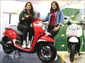  ?? FRIZAL/JAWA POS ?? ANGGUN: Ratu Bilqis (kiri) dan Zahra Hakim mencoba All New Honda Scoopy saat peluncuran di Surabaya akhir pekan lalu.