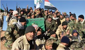  ?? AFP ?? Members of the Imam Ali Division, a group fighting with the Hashed Al Shaabi (Popular Mobilisati­on) paramilita­ry group, celebrate on Saturday after the victory announceme­nt