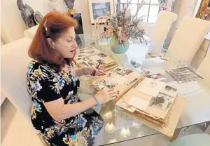  ?? MIKE STOCKER/STAFF PHOTOGRAPH­ER ?? Ann Schwartz, of Boynton Beach, who is donating Catskills memorabili­a to the Sandler Center in West Boca, looks over some old photos.