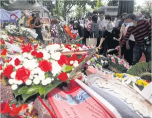  ?? NUTTHAWAT WICHEANBUT ?? People lay wreaths and flowers in remembranc­e of the Oct 6, 1976 massacre, during the memorial gathering at Thammasat University, Tha Prachan campus, yesterday.