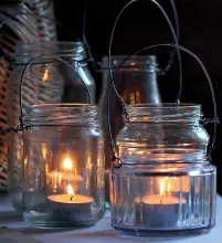  ??  ?? Flameless LED candles or tealights in jars make pretty outdoor lanterns, especially if you use them en masse.