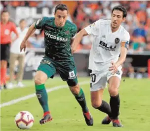  ?? EFE/JUAN CARLOS CÁRDENAS. ?? Guardado conduce ante la presión de Parejo