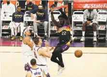  ?? Christian Petersen / Getty Images ?? Phoenix’s Deandre Ayton dunks on Denver’s Aaron Gordon (top), Nikola Jokic and Austin Rivers during the second half.