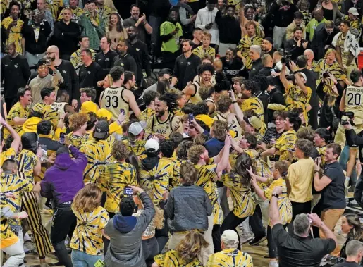  ?? AP ?? Duke’s Kyle Filipowski got his right knee banged up by a Wake Forest fan during this court-storming celebratio­n.