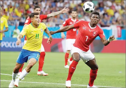  ??  ?? Brazil’s Philippe Coutinho (left), and Switzerlan­d’s Breel Embolo eye the ball during a Group E match at the 2018 soccer World Cup in the Rostov Arena
in Rostov-on-Don, Russia on June 17. (AP)