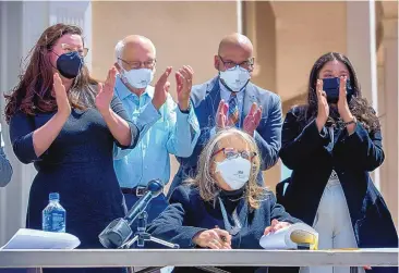  ?? EDDIE MOORE/JOURNAL ?? Legislator­s applaud outside the state Capitol Monday as Gov. Michelle Lujan Grisham signs a bill legalizing adult use of recreation­al cannabis. The lawmakers, from left, are Sen. Katy Duhigg, D-Albuquerqu­e; Sen. Gerald Ortiz y Pino, D-Albuquerqu­e; Rep. Javier Martinez, D-Albuquerqu­e; and Rep. Andrea Romero, D-Santa Fe. The law takes effect June 29, though legal sales will not begin until next year.