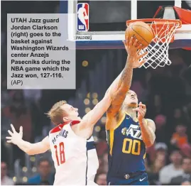  ?? (AP) ?? UTAH Jazz guard Jordan Clarkson (right) goes to the basket against Washington Wizards center Anzejs Pasecniks during the NBA game which the Jazz won, 127-116.