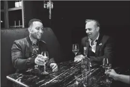  ?? JOHN FRANCIS PETERS / THE NEW YORK TIMES ?? John Legend, left, and French winemaker Jean-charles Boisset enjoy a glass at Heritage Fine Wines, in Beverly Hills, Calif.