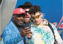  ?? DAVID J. PHILLIP/AP ?? Former Kansas City Chiefs player Christian Okoye poses with Kansas City Chiefs quarterbac­k Patrick Mahomes, right, and tight end Travis Kelce after arriving for Super Bowl 57 on Sunday in Phoenix.