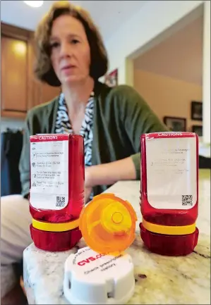  ?? MEL EVANS/AP PHOTO ?? Shelley Ewalt sits Sept. 18 in her Princeton, N.J., home near an open amber-colored CVS pharmacy prescripti­on bottle, center, and two uniquely designed red ones from Target. Since CVS took over operation of Target’s drugstores earlier this year,...