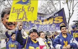  ?? RICHARD VOGEL / AP ?? Felix Gonzalez (center) and his dog Milo join Rams fans hoping for the team’s return to L.A. during a rally at the Los Angeles Memorial Coliseum last weekend.