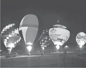  ?? PHOTO TRIBUNE FILE ?? Night Glow, a popular attraction during the Coshocton Hot Air Balloon Festival, draws spectators from far and wide. Balloonist­s use flames to light up their balloons to music for viewers on Saturday evening of the festival.